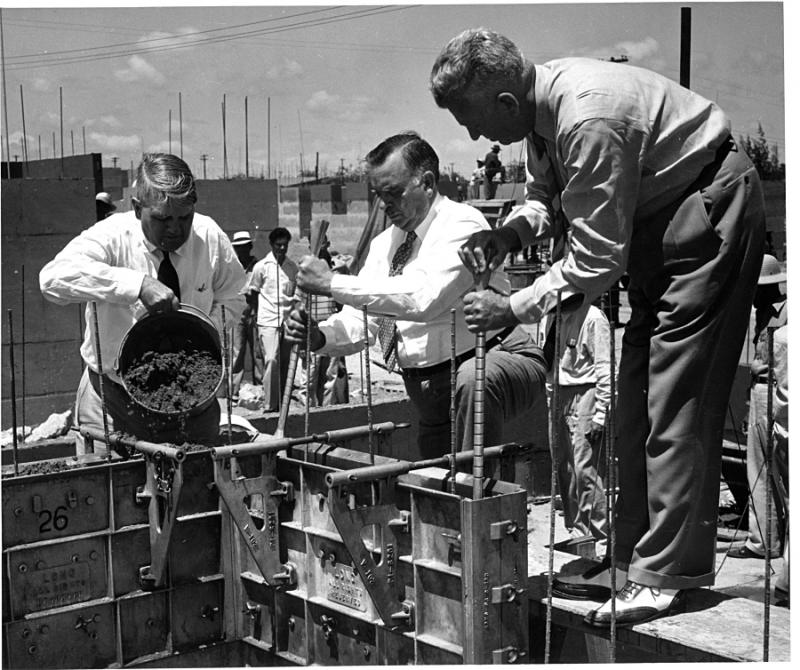 Frederick Carpenter, Jesús T. Piñero y Leonard D. Long bajan un molde en la construcción de las viviendas.